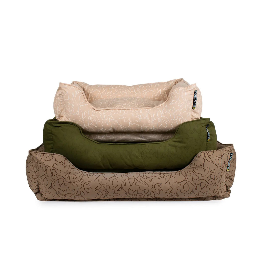 three patterned pet beds, one beige, one green, and one brown stacked on a white background.