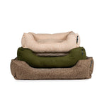 Three stacked patterned pet beds, one beige, one green and one brown on a white background.