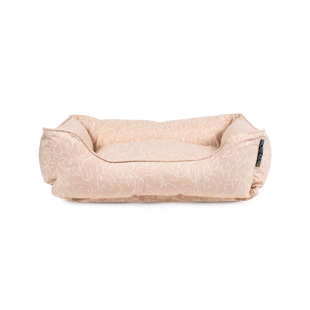 Beige dog bed with subtle pattern on a white background