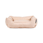 Beige dog bed with subtle pattern on a white background