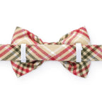 Plaid bow tie with red, beige, and green pattern on a white background
